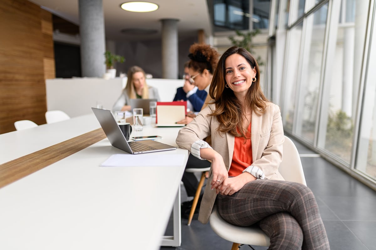 Portrait of female manager with laptop working in meeting room