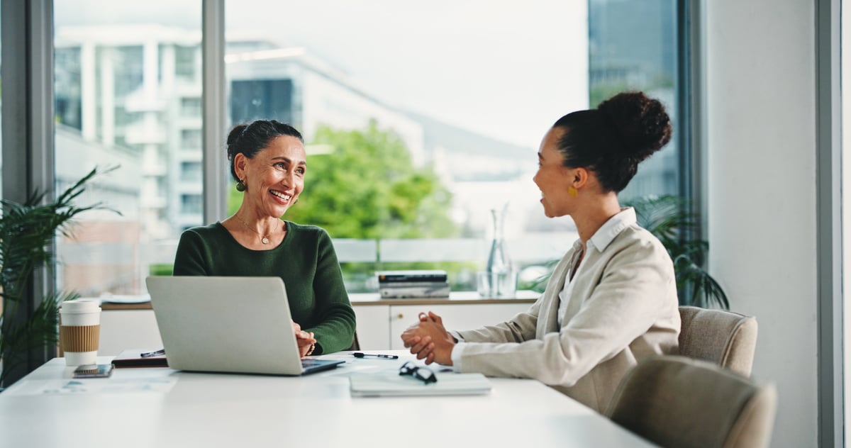 Laptop, discussion and business women in office with feedback on corporate performance review